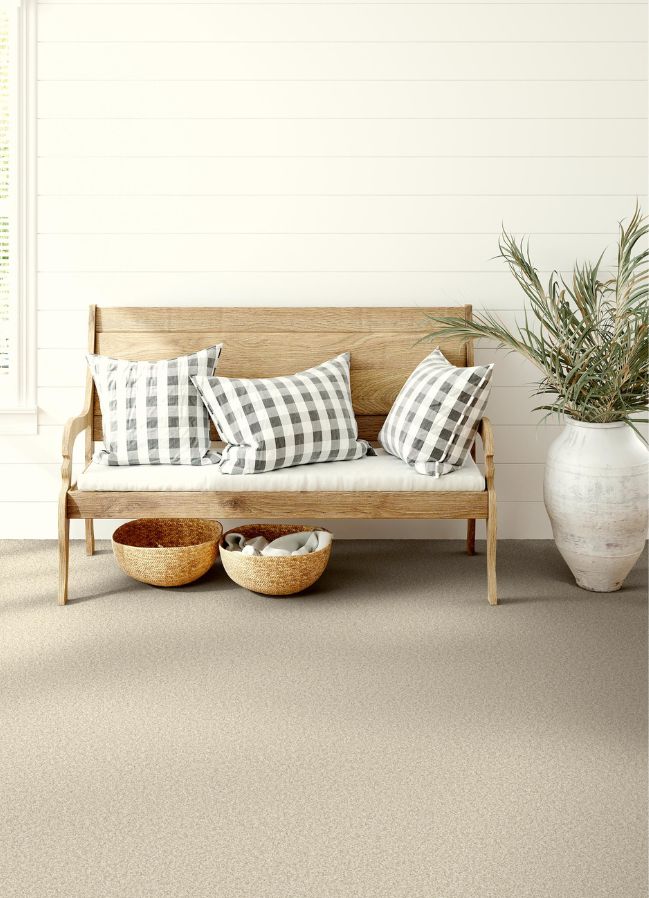 beige carpets in an entryway with a bench