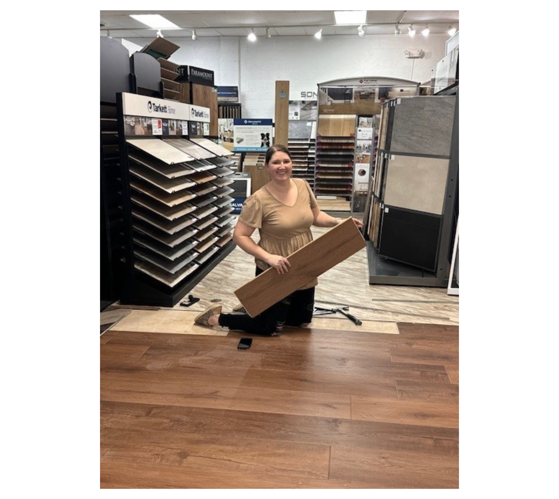 Employee working on installation of hardwood flooring in the showroom.